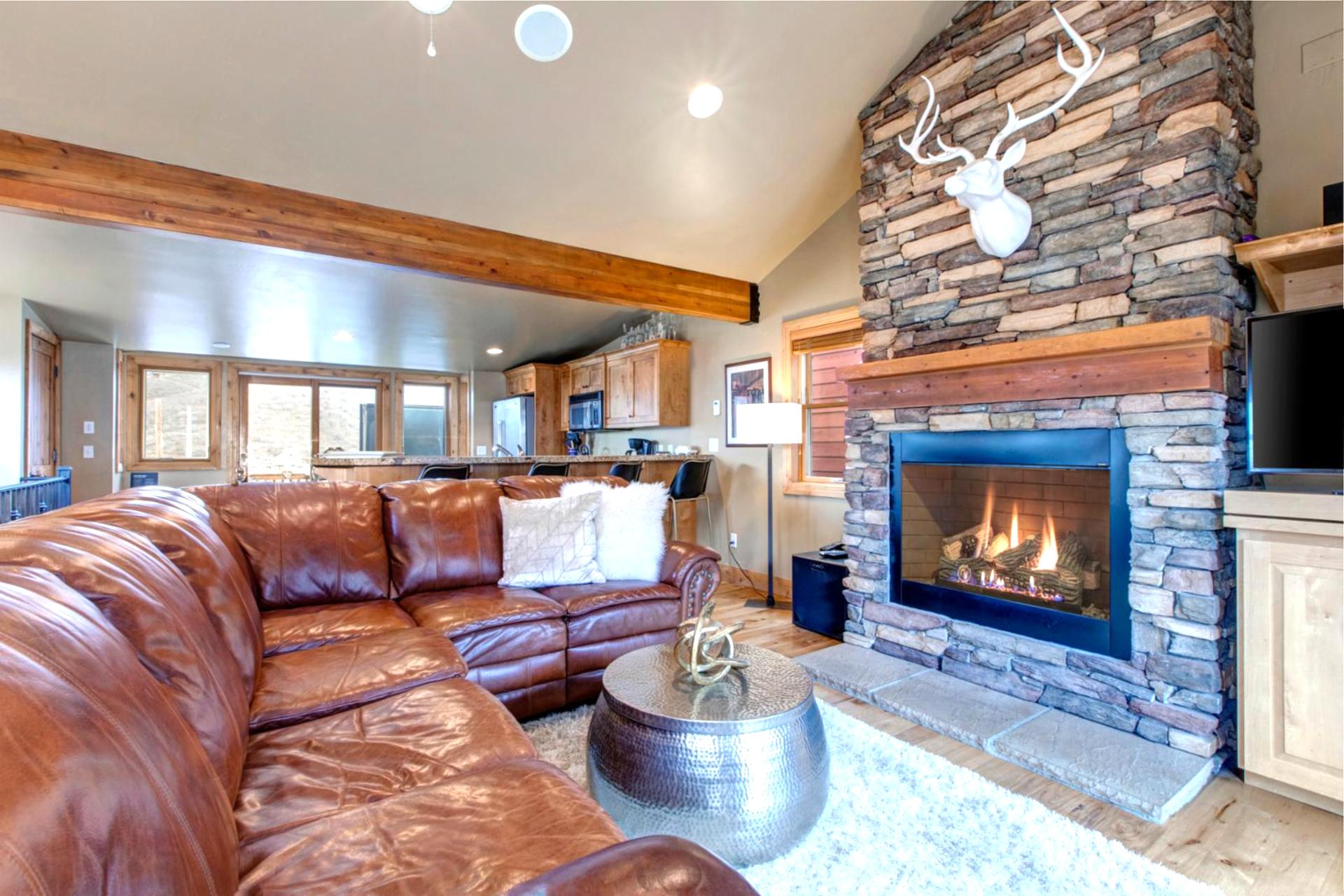 Gather in the cozy living room with a fireplace, leather seating, and a flat-screen TV for movie nights.