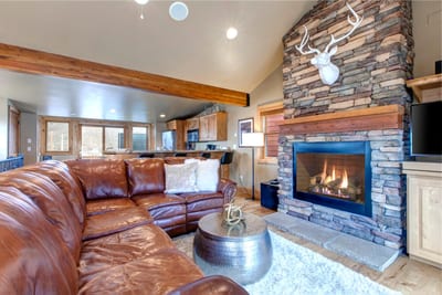 Gather in the cozy living room with a fireplace, leather seating, and a flat-screen TV for movie nights.