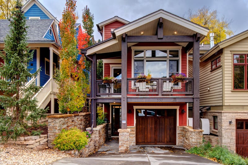 Front steps lead to a covered entry framed by rich wood and stone.