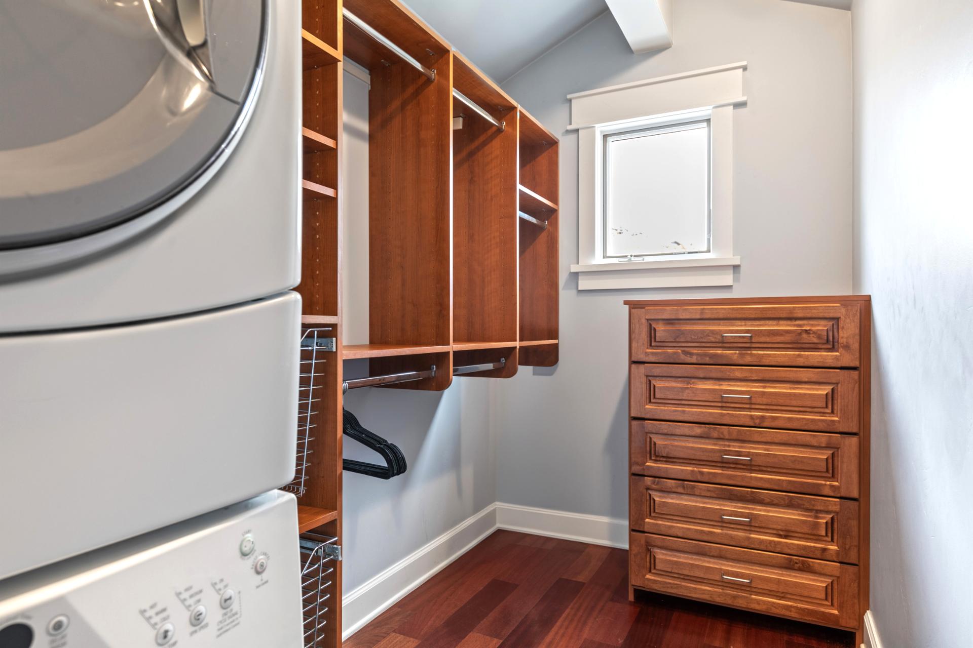 Upstairs laundry with washer, dryer, and built-in storage for convenience during extended stays.