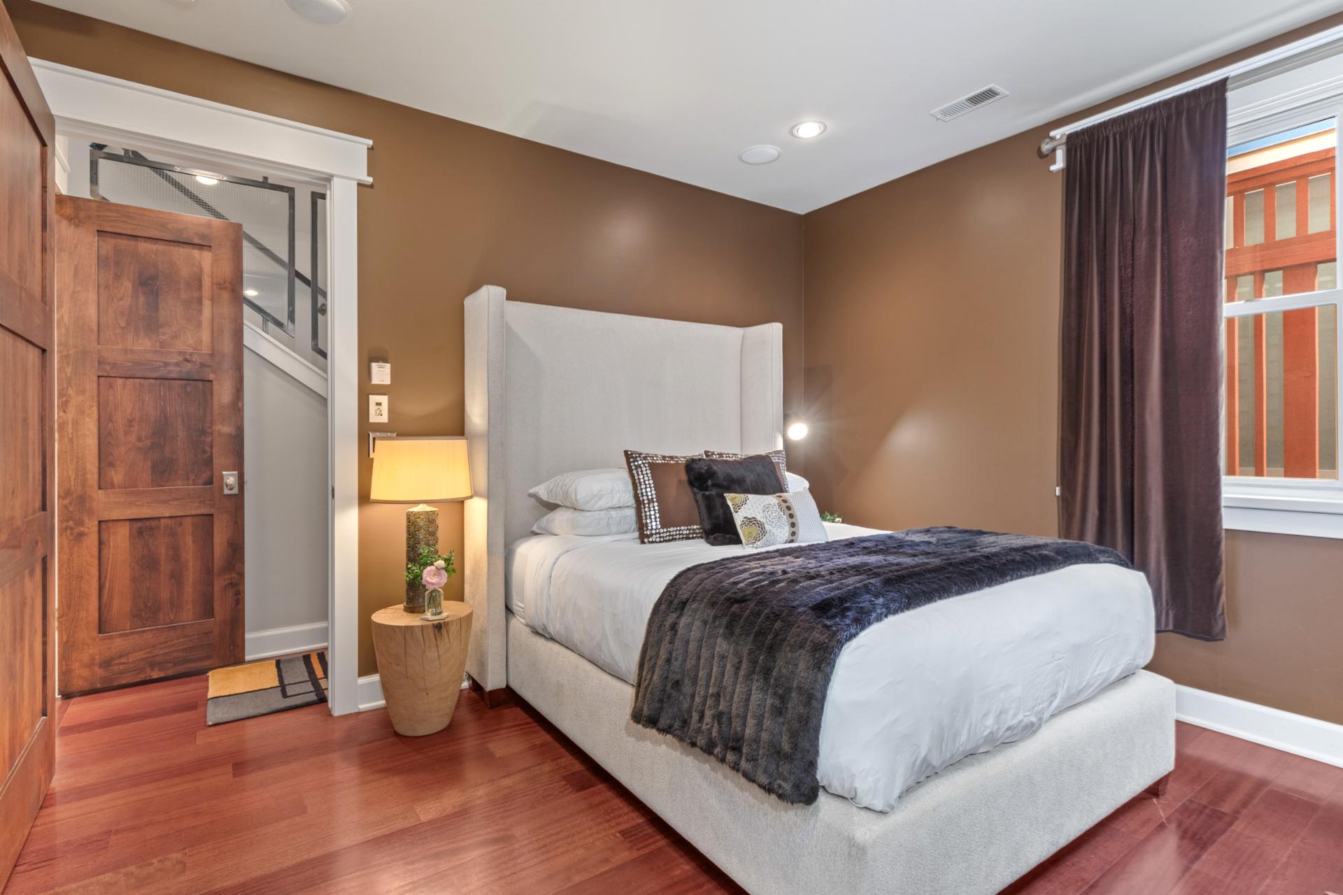 Bedroom 2 features a Queen bed, warm wood accents, and access to the shared bath.