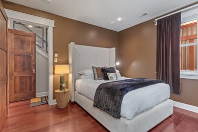 Bedroom 2 features a Queen bed, warm wood accents, and access to the shared bath.