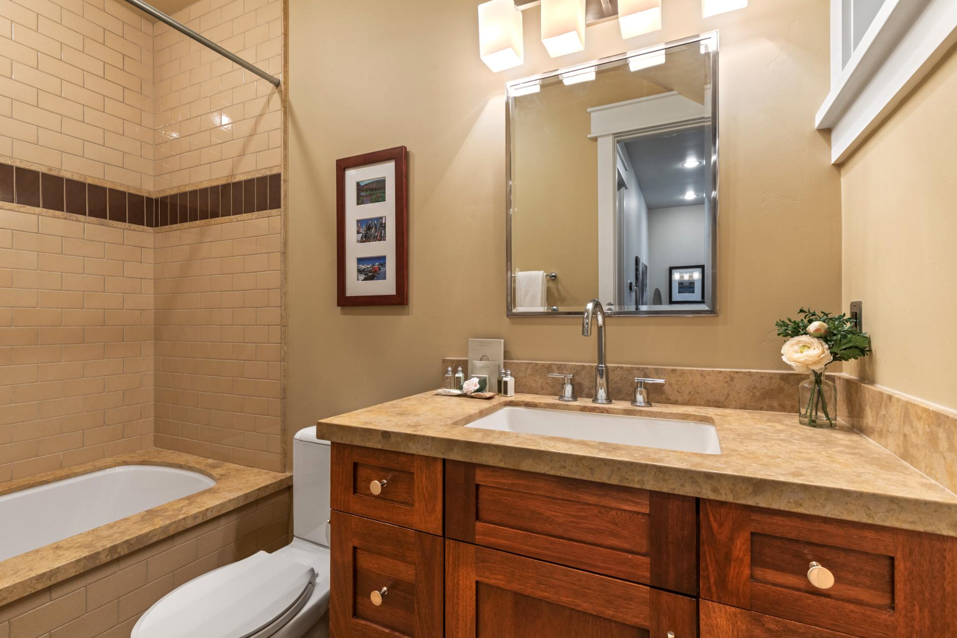 Shared bath includes a granite vanity, large mirror, and full tub/shower combo.
