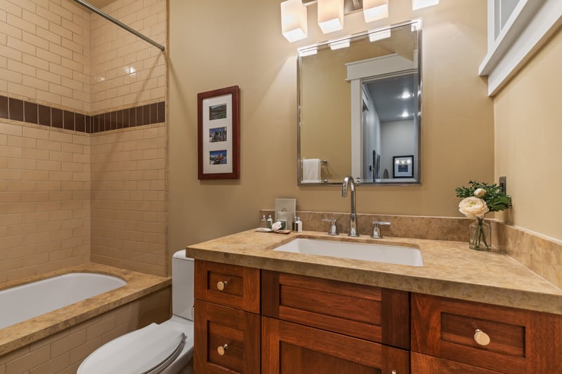 Shared bath includes a granite vanity, large mirror, and full tub/shower combo.
