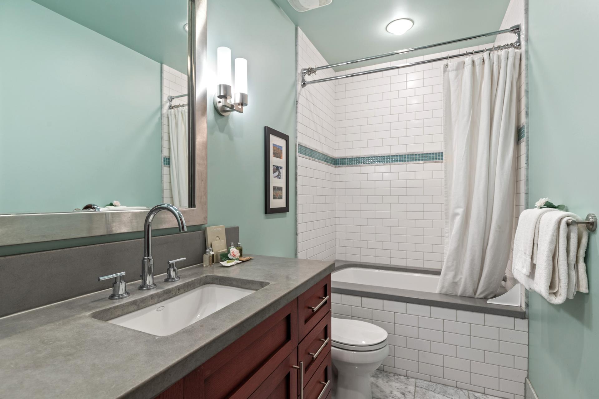 Attached to the bunk room, this bath includes a full-size tub and shower with modern tile.