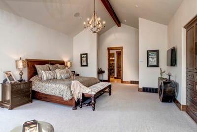 Wake up in your spacious primary suite with a King bed, vaulted ceilings, an elegant chandelier, and direct access to a luxe ensuite bath.