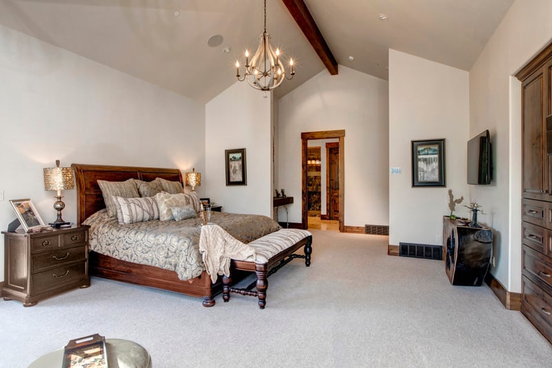 Wake up in your spacious primary suite with a King bed, vaulted ceilings, an elegant chandelier, and direct access to a luxe ensuite bath.