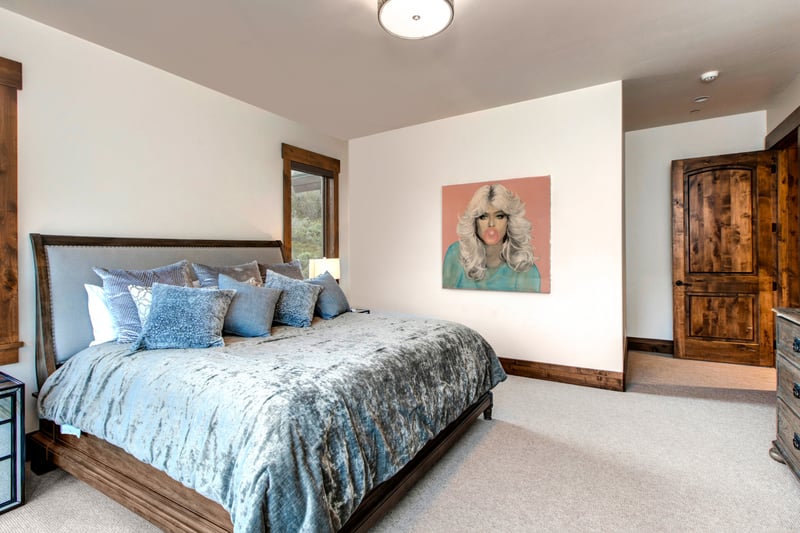 Chic bedroom with velvet bedding, modern art, and rustic charm.