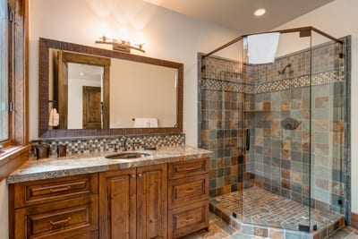 En suite bath to Guest Bedroom 1 features granite finishes and a tub/shower combo.