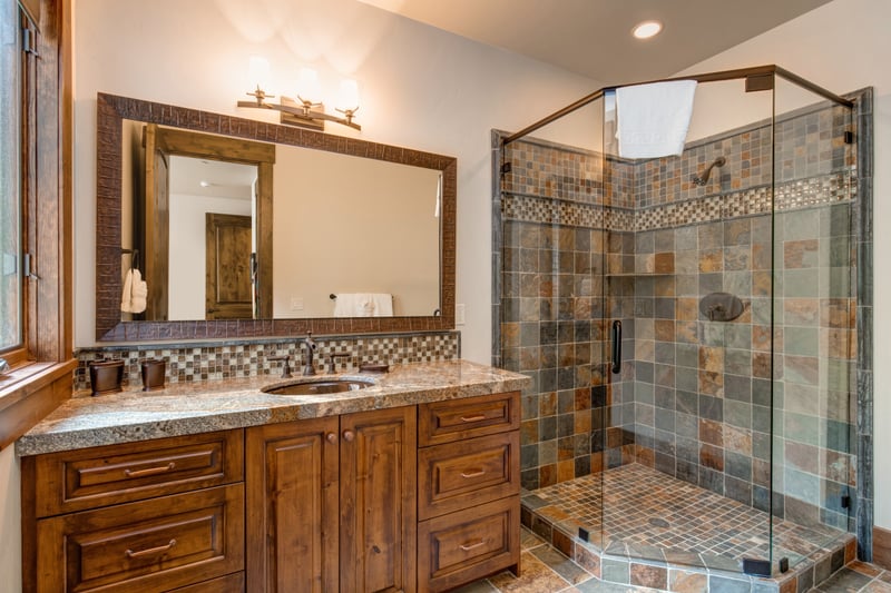 En suite bath to features granite finishes and a step in shower.