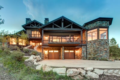 Arrive in style to this four-story mountain retreat with timber framing, stacked stone, and glowing windows that hint at the luxury within.
