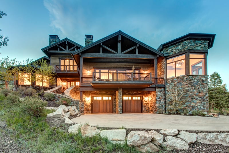 Arrive in style to this four-story mountain retreat with timber framing, stacked stone, and glowing windows that hint at the luxury within.