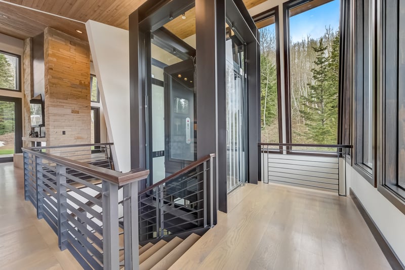 Architectural staircase and expansive windows define the central flow of the home.