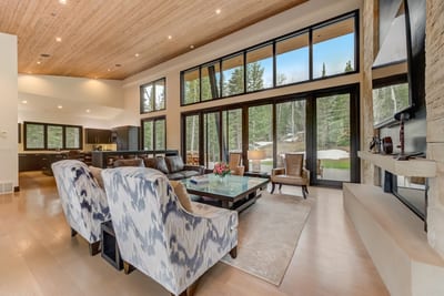 Multiple seating zones and large windows create a versatile, light-filled living area.