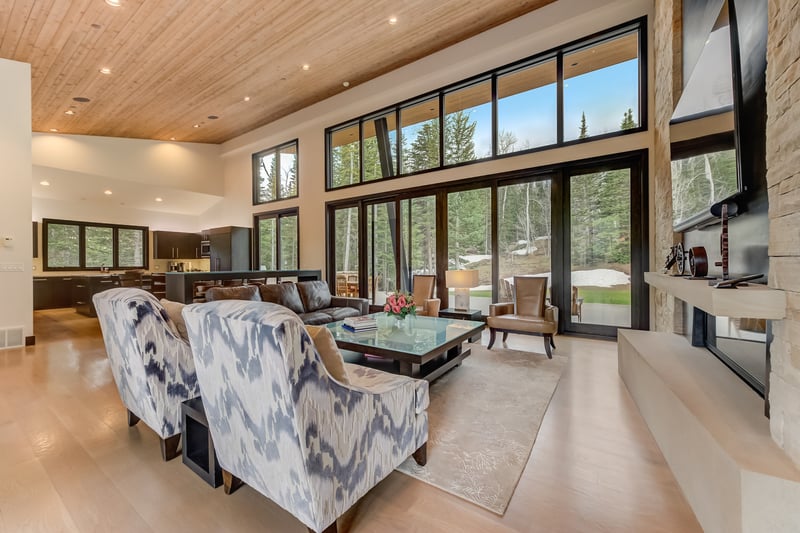 Multiple seating zones and large windows create a versatile, light-filled living area.