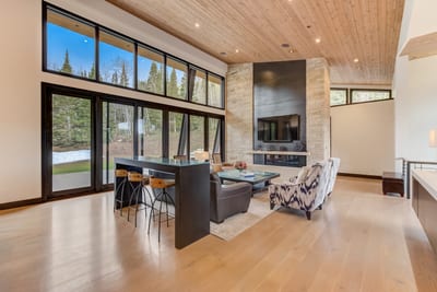 Gather by the fireplace or look out over the trees in this central great room.
