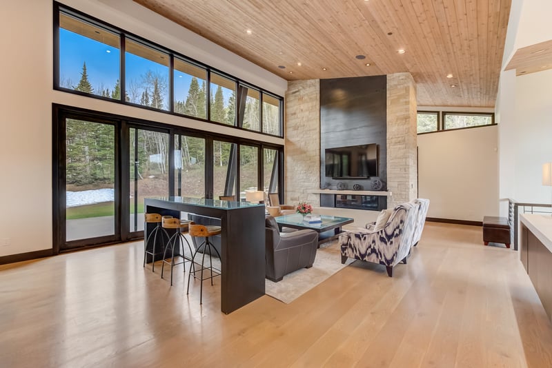 Gather by the fireplace or look out over the trees in this central great room.
