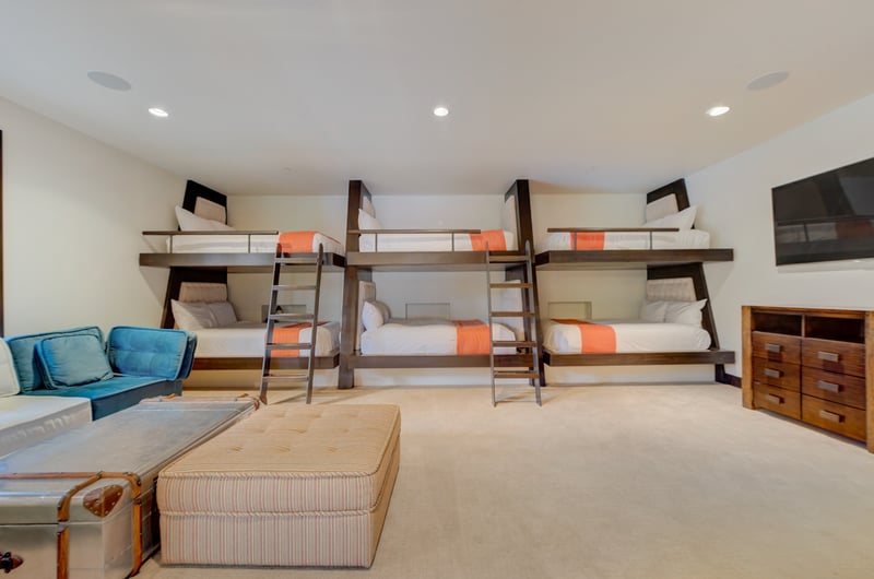 The bunk room features three built-in Queen-over-Queen beds with space for the whole crew.