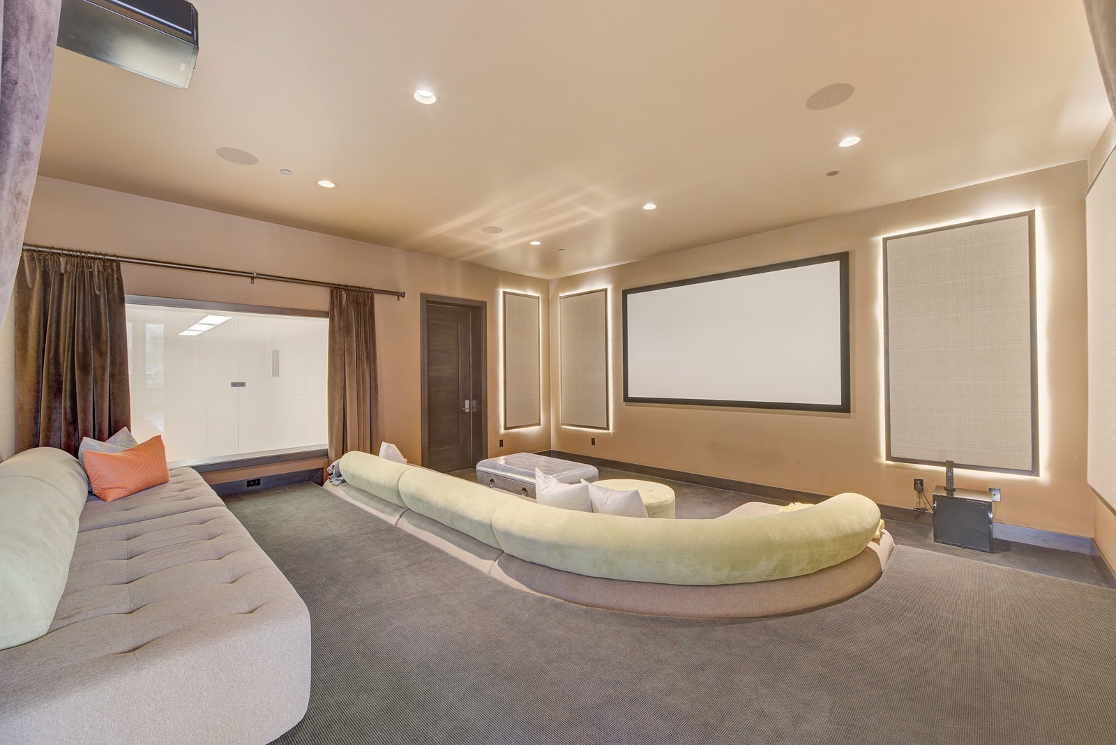 Cushioned seating and projection screen turn this room into your personal theater.