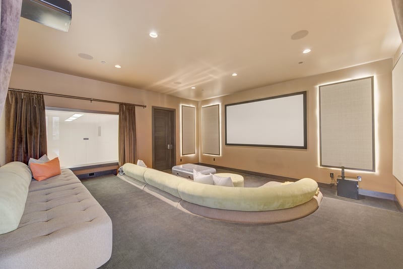 Cushioned seating and projection screen turn this room into your personal theater.
