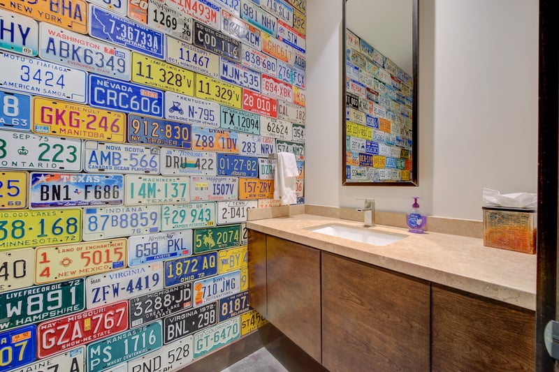 Half bath with playful license plate wall adds a fun pop to the space.