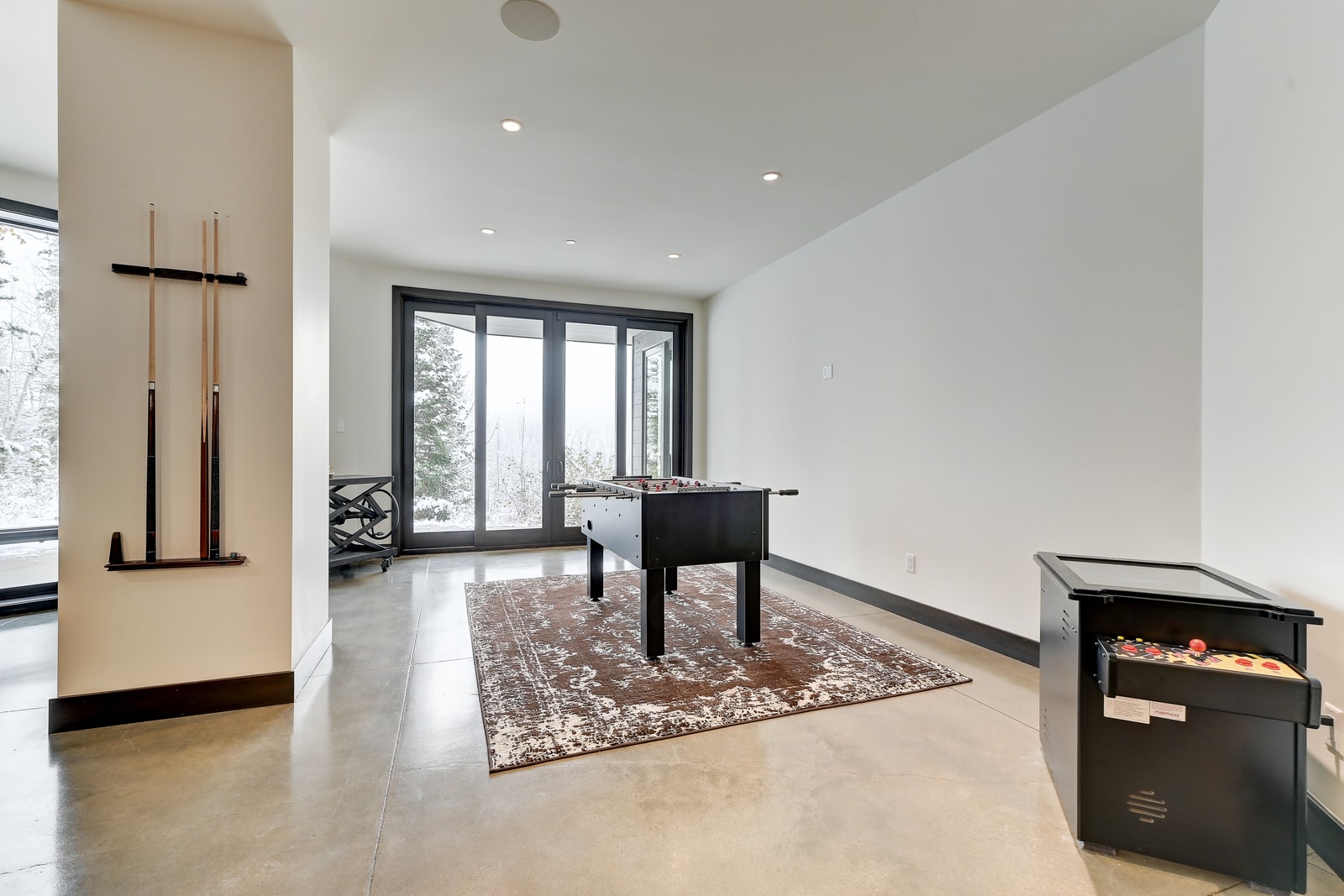 Lower-level rec space includes games, lounging, and access to the patio.