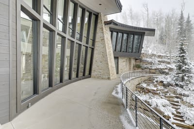 Curved balcony offers a peaceful perch above the snow-dusted forest. PCO-184M