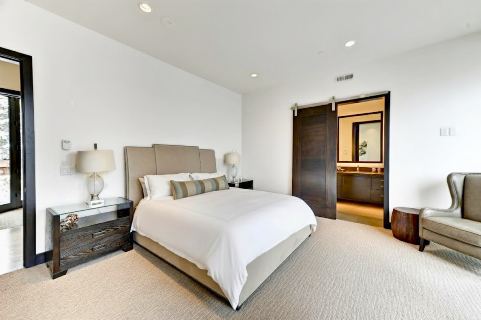 Primary King bedroom offers plush bedding, lounge space, and serene views.