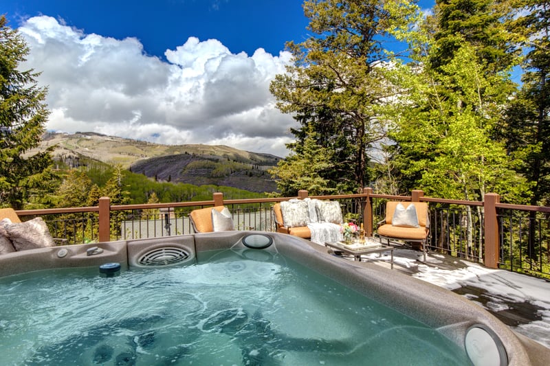 This sunny deck features hot tub, mountain views, and room to gather.