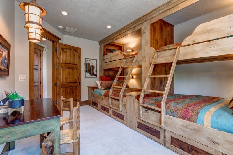 Upper-level bunk room with custom wood bunks and vibrant bedding.