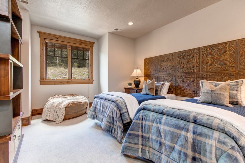 Soft natural light and mountain touches make this a cozy twin bedroom.