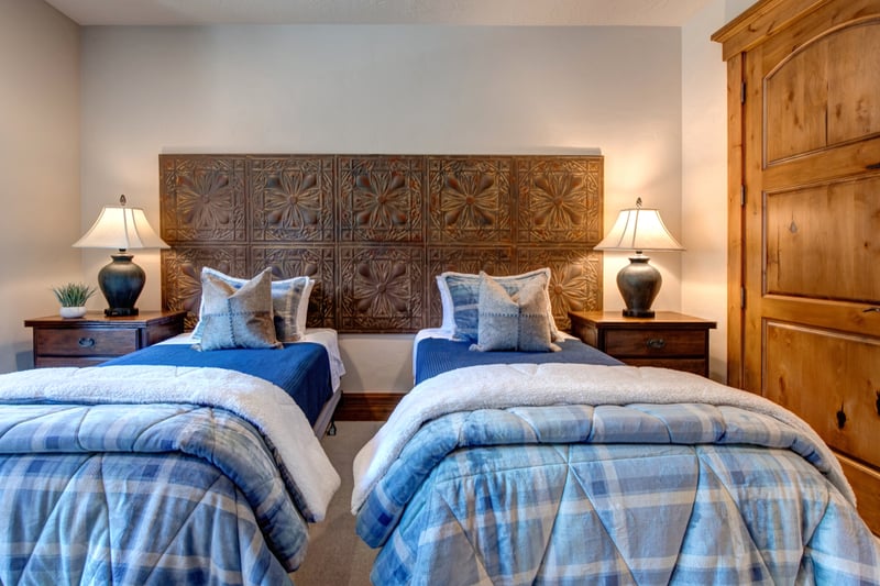 Matching twin beds, playful blue linens, and custom wood headboards.