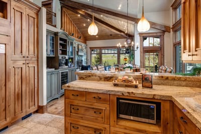Wide-angle of the main kitchen shows breakfast bar seating and expansive workspace.