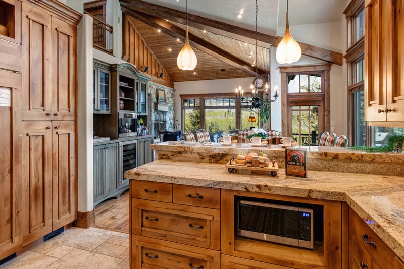Wide-angle of the main kitchen shows breakfast bar seating and expansive workspace.