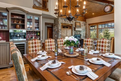 Your dining table is set for ten, with upholstered chairs and chandelier lighting.