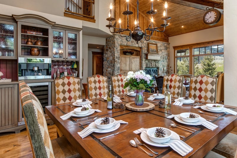 Your dining table is set for ten, with upholstered chairs and chandelier lighting.