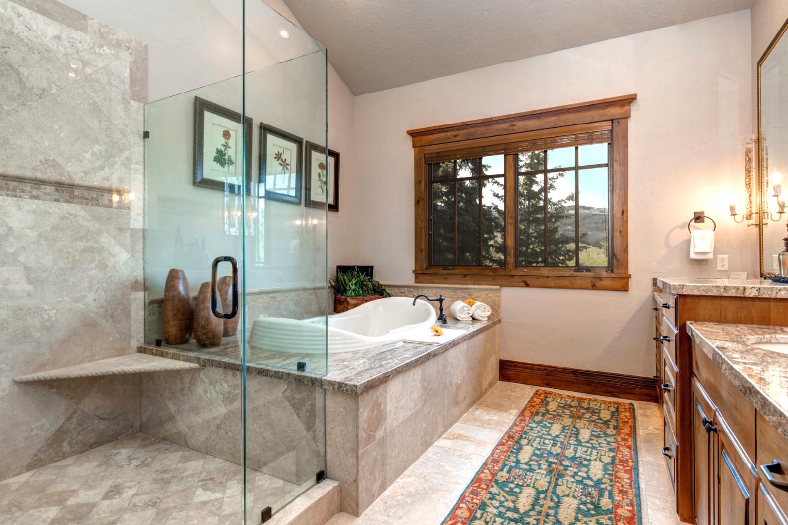 Your en suite bath offers a soaking tub, walk-in shower, and forest views.