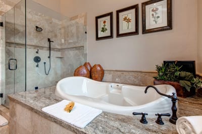Soak beneath a chandelier with framed art and tranquil surroundings in your spa bath.