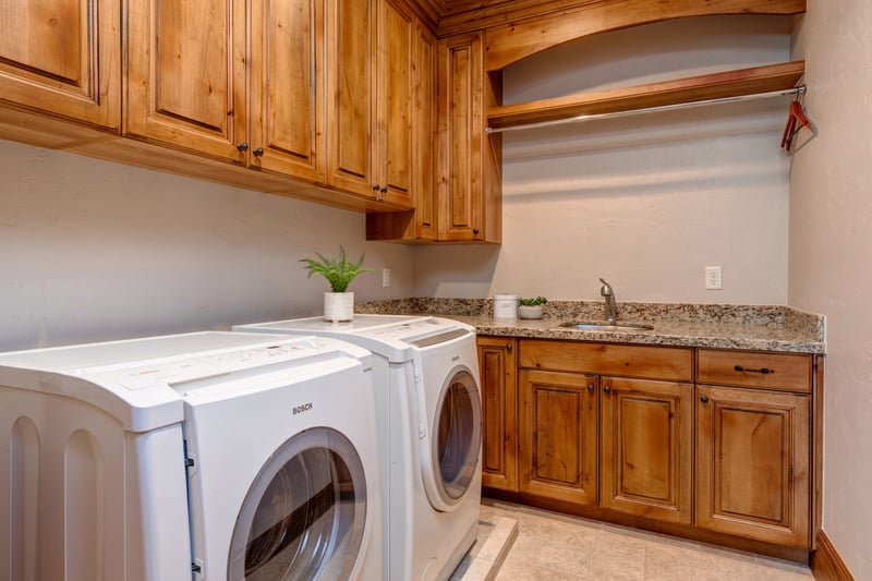 Full laundry room with extra counter space and custom wood cabinetry.