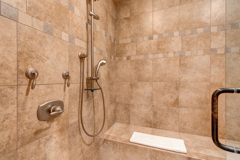 Detail of the rainfall shower fixtures and built-in bench seat in the guest bathroom.