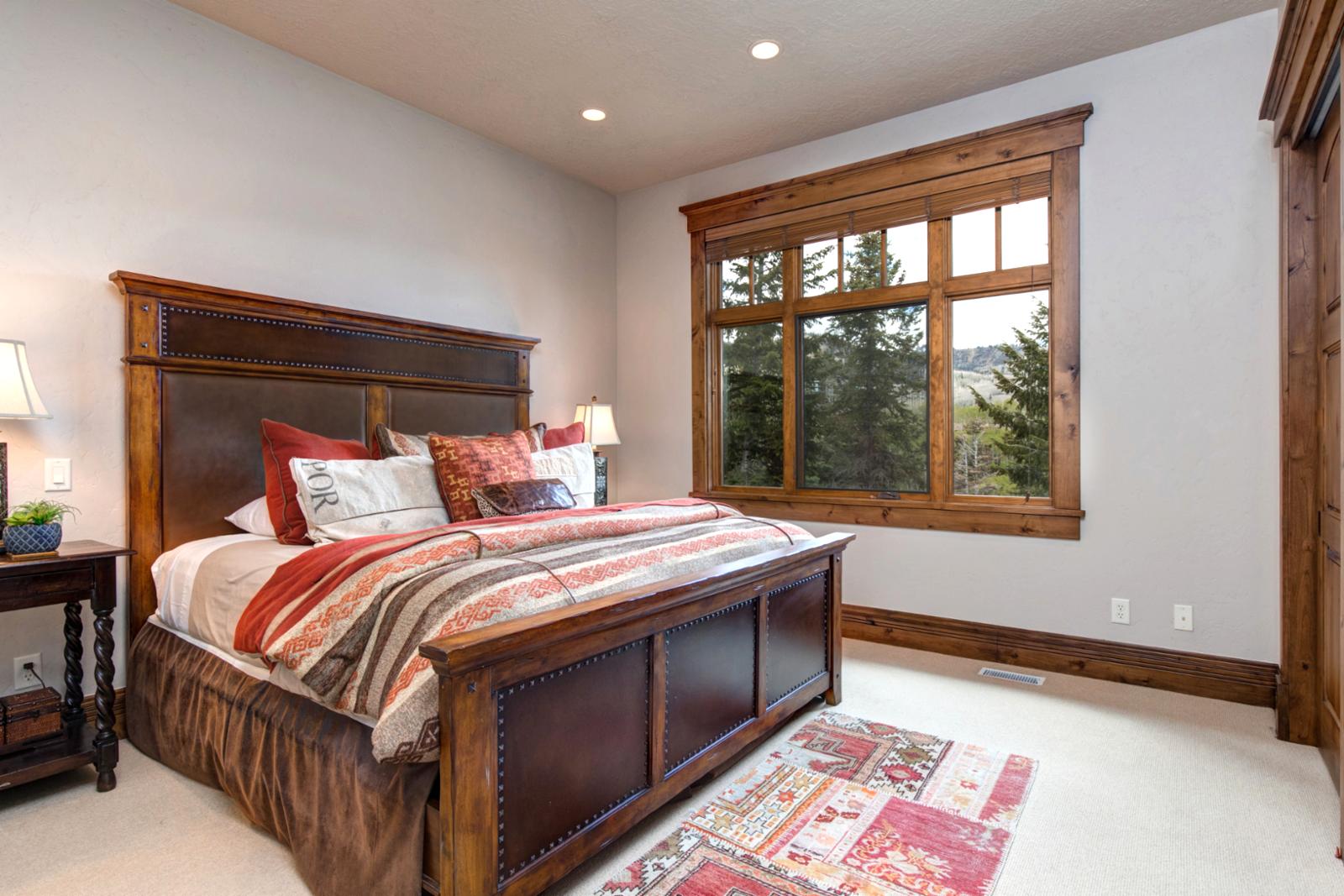 Main-level guest room with King bed, plush linens, and mountain views.