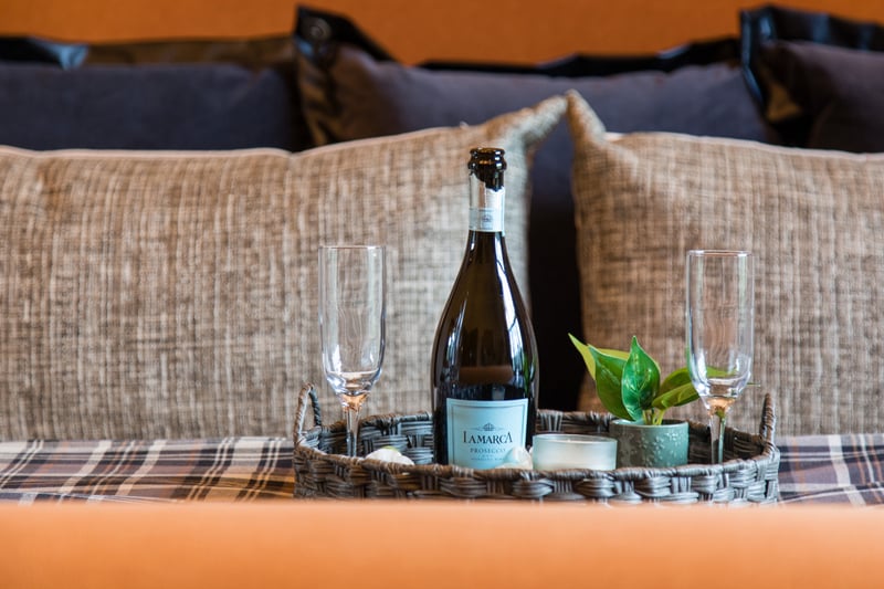 Elegant touches like tufted bedding and champagne tray invite rest and celebration.