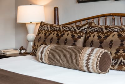 Pillow detail and side lighting highlight this peaceful lower-level bedroom.