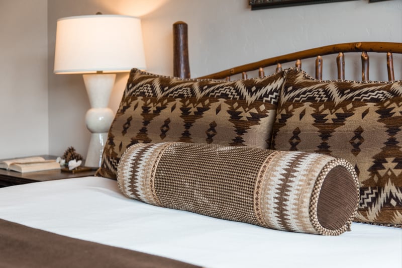 Pillow detail and side lighting highlight this peaceful lower-level bedroom.