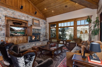 Rustic wood beams and rich leather seating create a warm, lodge-inspired space for conversation or quiet reading.