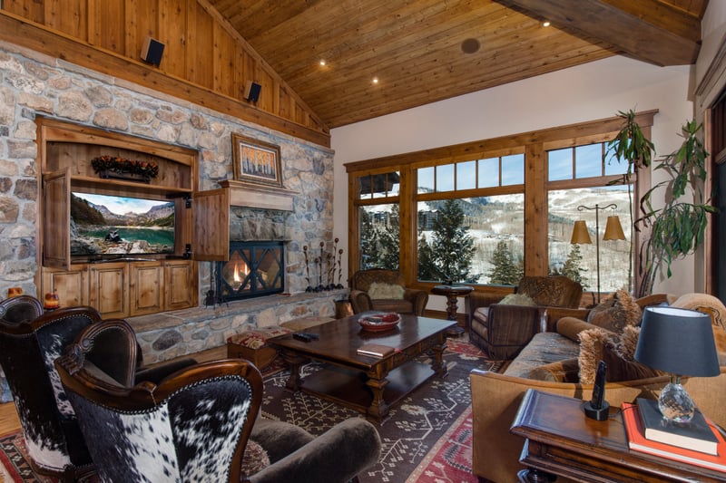 Rustic wood beams and rich leather seating create a warm, lodge-inspired space for conversation or quiet reading.