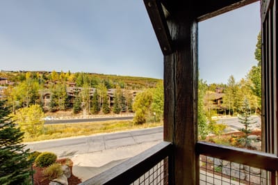 Enjoy peaceful balcony views of pine trees, hillside homes, and a quiet mountain road—perfect for morning coffee or golden hour.