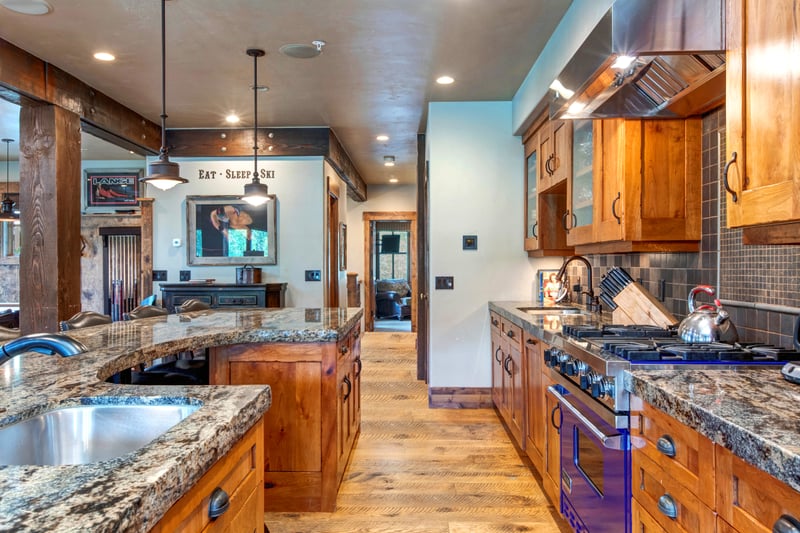 A closer look at the fully equipped kitchen reveals stainless appliances, rustic cabinetry, and a spacious layout for group meals.