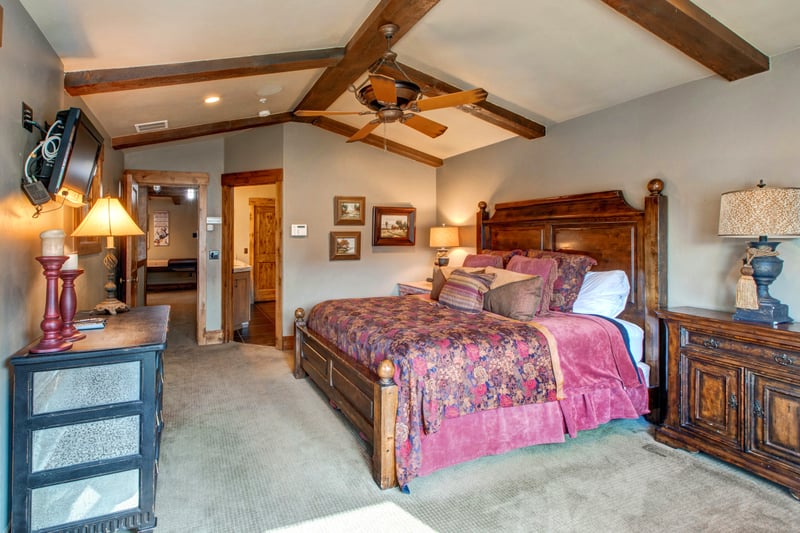 Unwind in your spacious upstairs primary suite with a King bed, exposed beams, and warm-toned mountain décor.