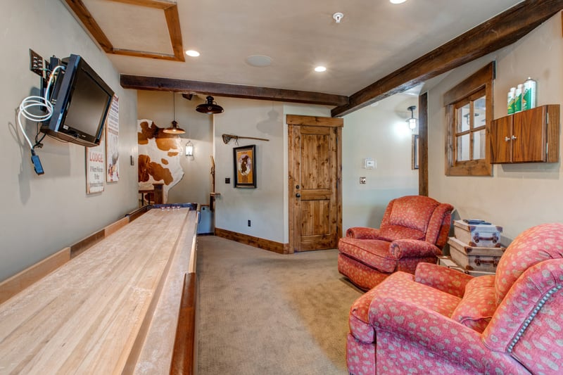 Enjoy friendly competition in the game room with shuffleboard, plush chairs, and rustic mountain touches.